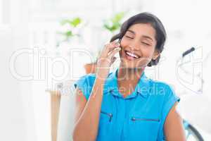 Casual businesswoman using cellphone in office
