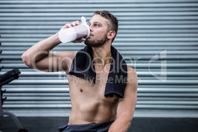 Muscular man drinking protein cocktail