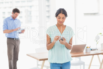 Casual colleagues using digital tablet and telephone