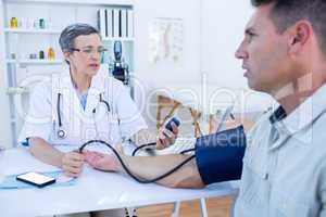 Doctor checking blood pressure of her patient