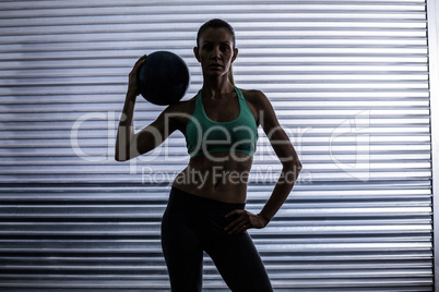 Muscular woman holding a medicine ball