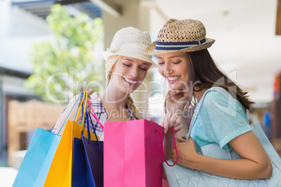 Two happy women looking at shopping bags