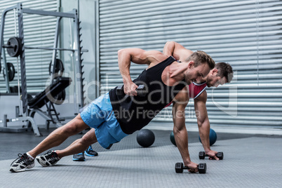 Muscular men doing a side plank