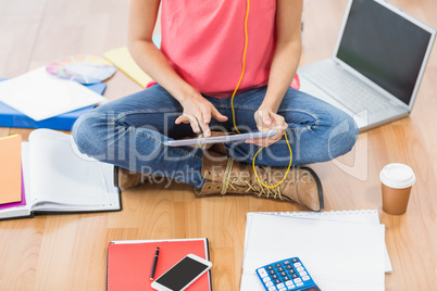 Young creative businesswoman scrolling on tablet