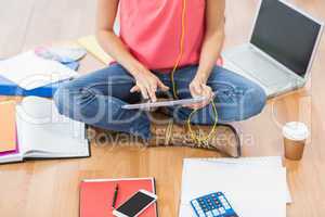 Young creative businesswoman scrolling on tablet