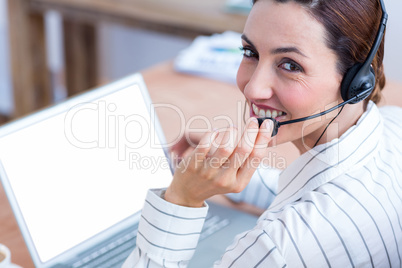 Brunette businesswoman using laptop and headphone