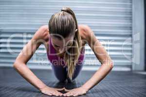 A muscular woman on a plank position