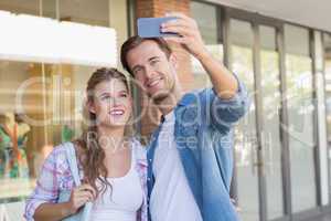 A smiling happy couple taking selfies