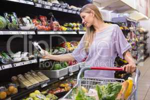 Smiling woman taking a vegetables in the aisle