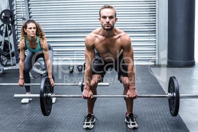 Muscular couple lifting weight together Muscular couple lifting weight together