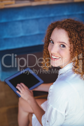 Pretty girl using a small tablet at table