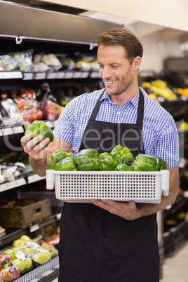 Smiling handsome worker taking a box with vegetable