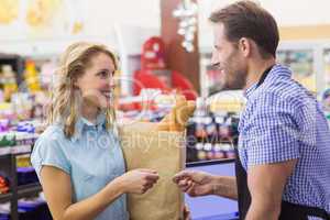 Smilingm woman at cash register paying with credit card