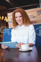 Pretty girl using a small tablet at table