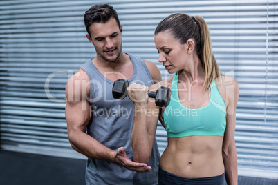 A muscular woman lifting dumbbells