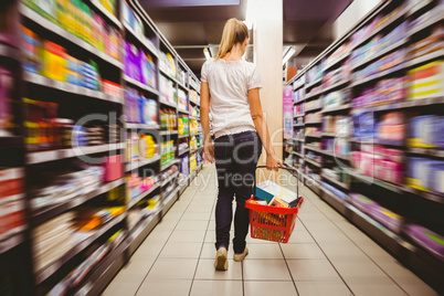 Photo of a woman walking with his trolley on aisle on selective