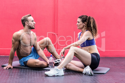 Sitting muscular couple talking together