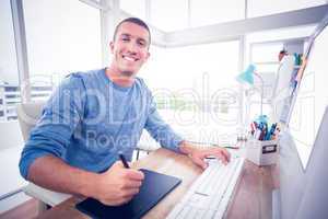 Young creative businessman drawing on graphic tablet