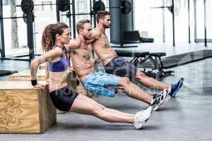 Three muscular athletes doing planking