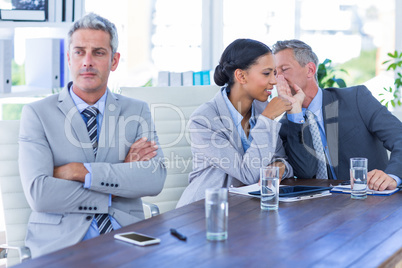 Sad businessman looking aways while his colleagues speaks