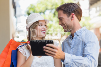 Cute smiling couple looking a tablet