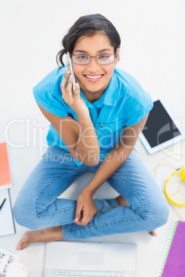 Casual businesswoman calling while siting on the floor