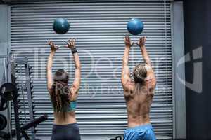 Muscular couple throwing ball in the air