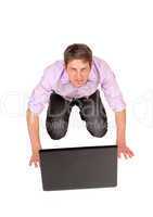Man kneeling in front of laptop.