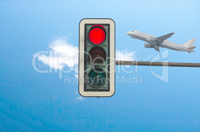 Rote Ampel  im Hintergrund ein Flugzeug.
