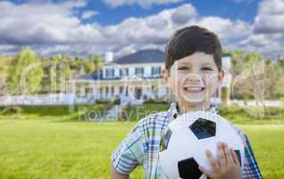 Smiling Young Boy Holding Soccer Ball In Front of House