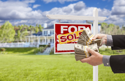 Man Handing Over Money in Front Sold House and Sign