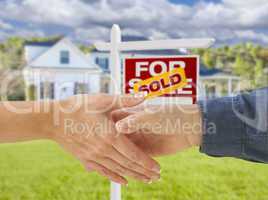 Shaking Hands in Front of New House and Sold Sign
