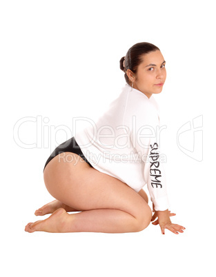 Woman in white shirt kneeling on floor.