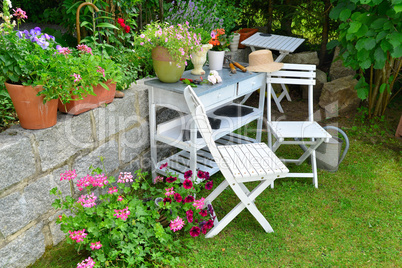 weißer Stuhl im Garten mit Blumen