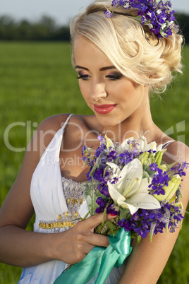 Beautiful bride blond blue eyes green field