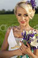 Beautiful bride blond blue eyes green field