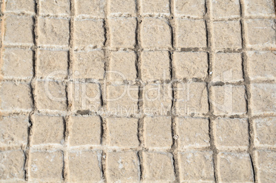 Old floor tiles small beige stone pavement