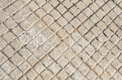 Old floor tiles small beige stone pavement in brace