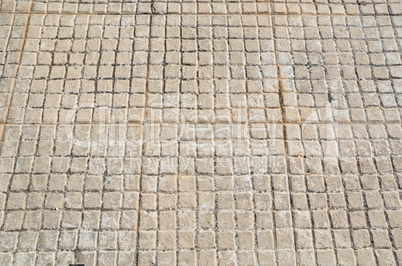 Old floor tiles small beige stone pavement