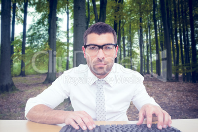 Composite image of businessman working at his desk