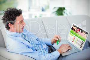 Composite image of businessman doing online shopping on couch