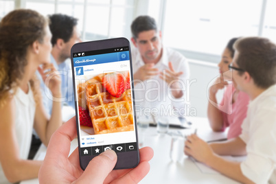 Composite image of female hand holding a smartphone