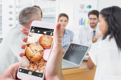 Composite image of hand holding smartphone