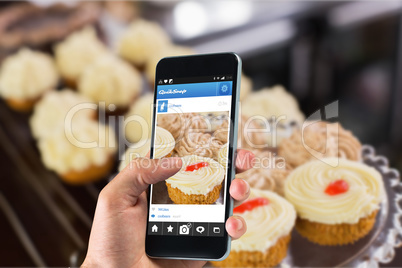 Composite image of hand holding smartphone