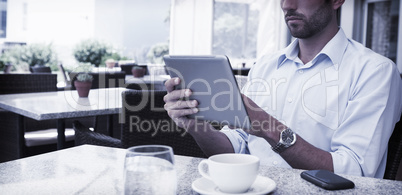 Focused young businessman working on tablet