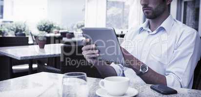 Focused young businessman working on tablet