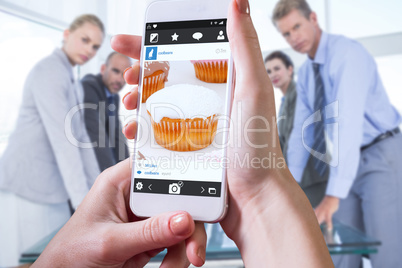 Composite image of hand holding smartphone