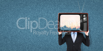 Composite image of businessman hiding head with a box