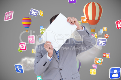 Composite image of businessman holding blank sign in front of hi