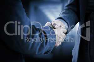 Composite image of business people shaking hands close up